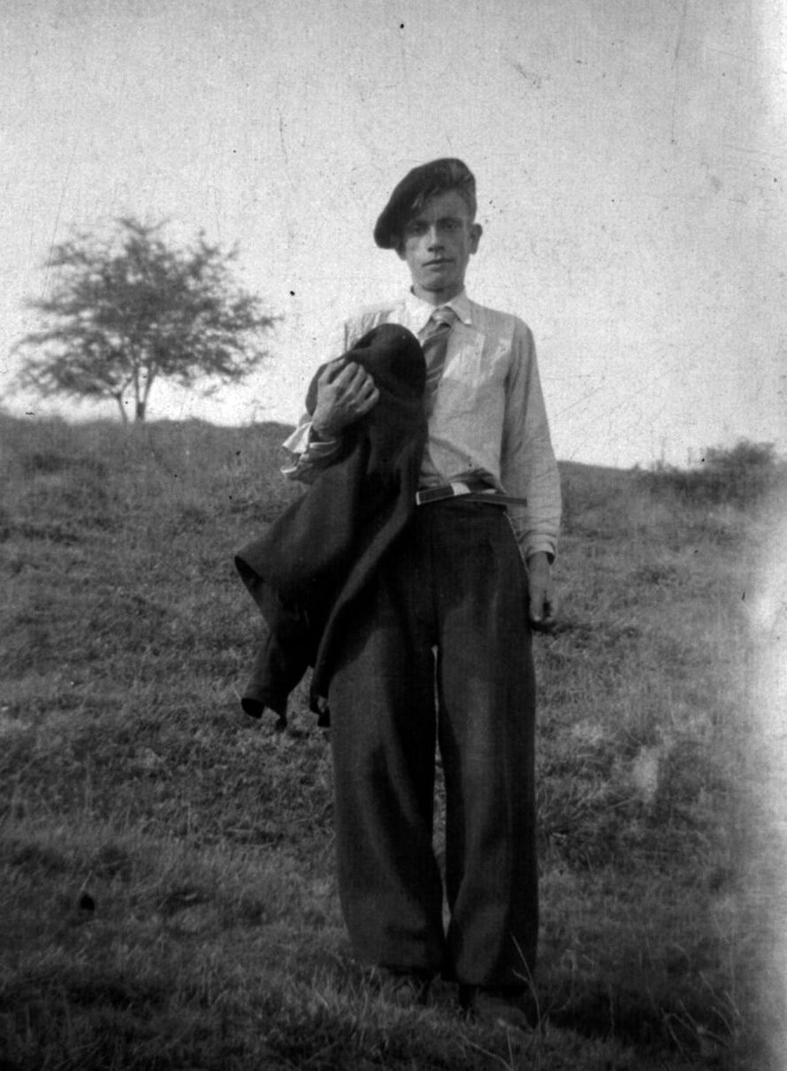 Jeune homme posant debout dans un pré en Ardèche. Il tient sa veste sur le bras et porte un béret. Photo issue des archives familiales de l'auteur et prise vers 1942.